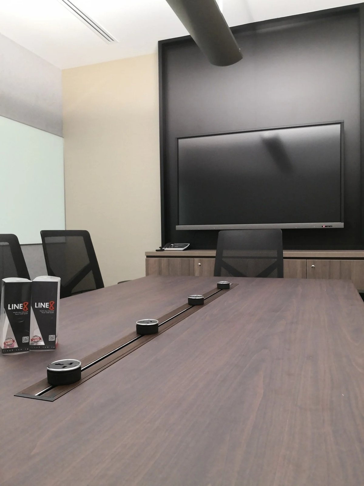 Line8 Model SL track in Black Hairline along a conference room table powering devices