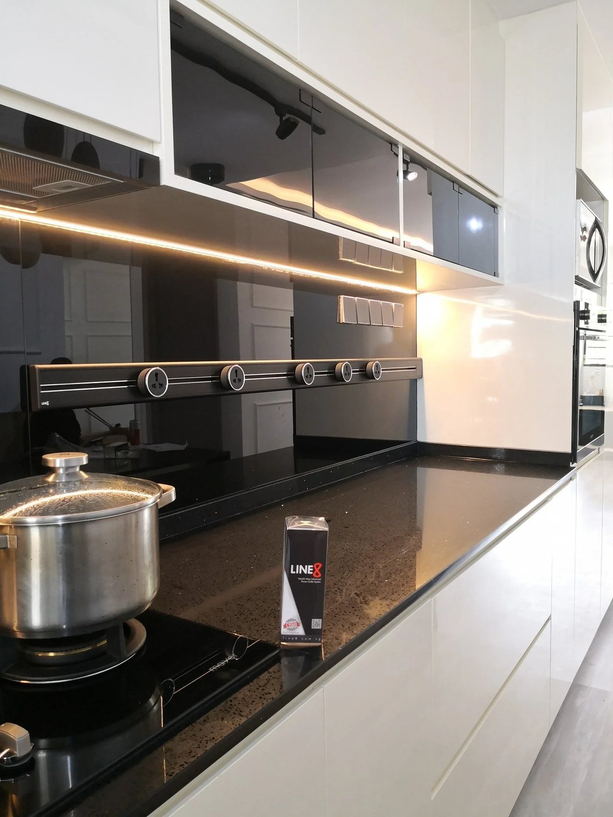 Line8 Model SL track in Black Hairline above a kitchen countertop with a pot and black backsplash