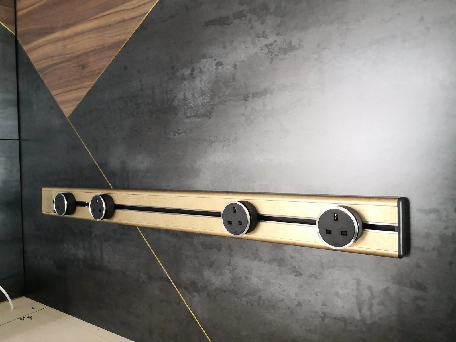 Line8 Model SL track in Champagne Gold mounted on a wall with power outlets