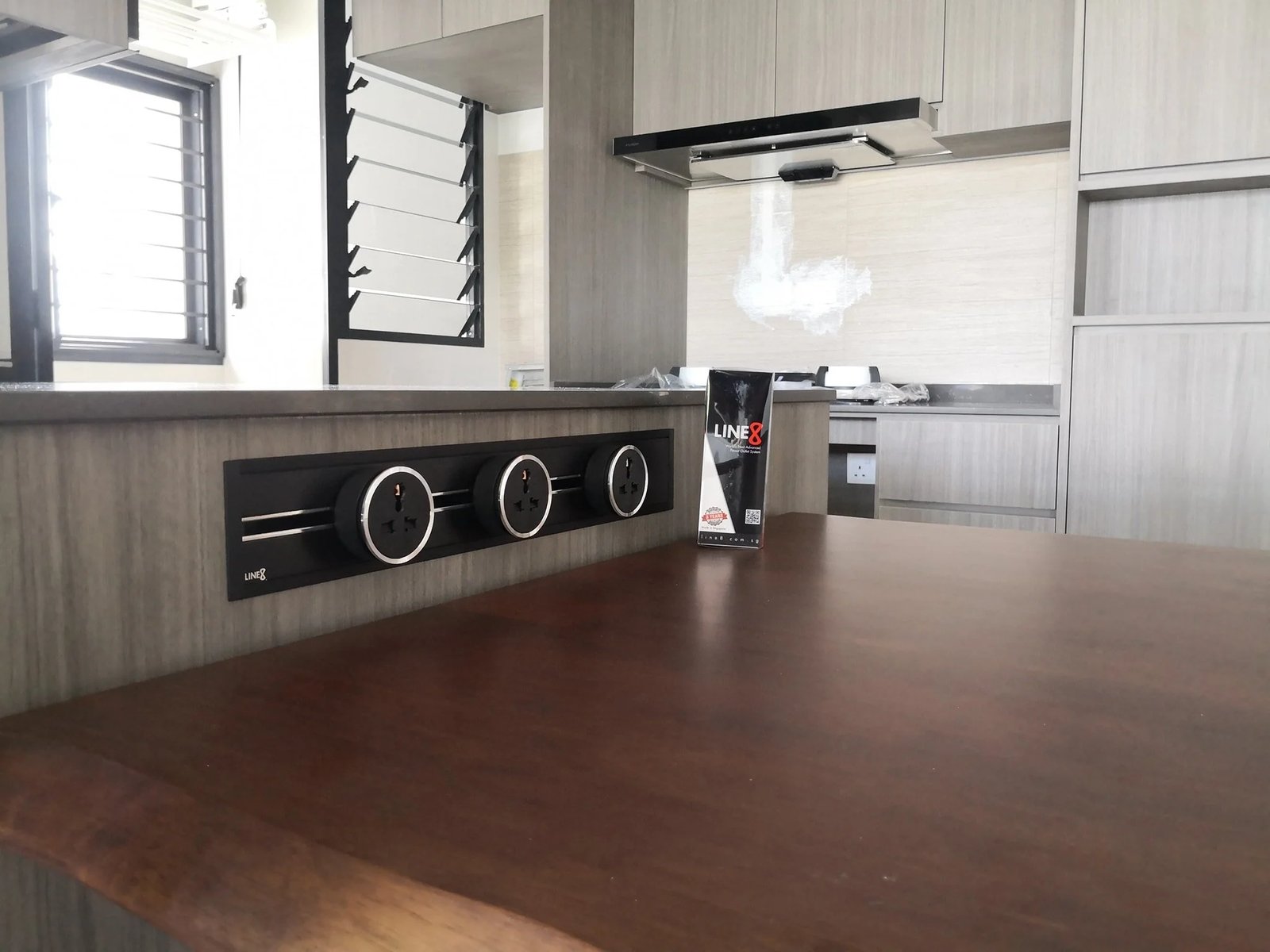 Line8 Model SL track in Black Hairline above a kitchen island powering outlets