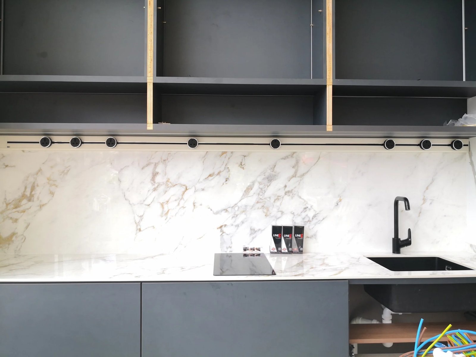 Line8 Model SL track in Black Hairline above a kitchen sink with a marble splashback