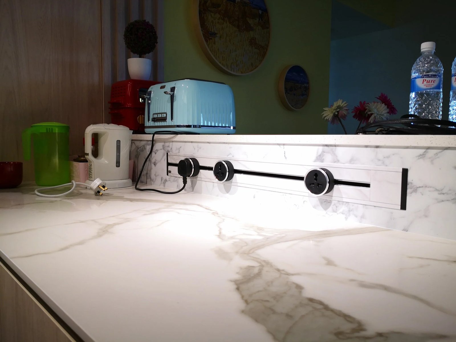 Line8 Model SL track in White Marble along a kitchen countertop powering appliances