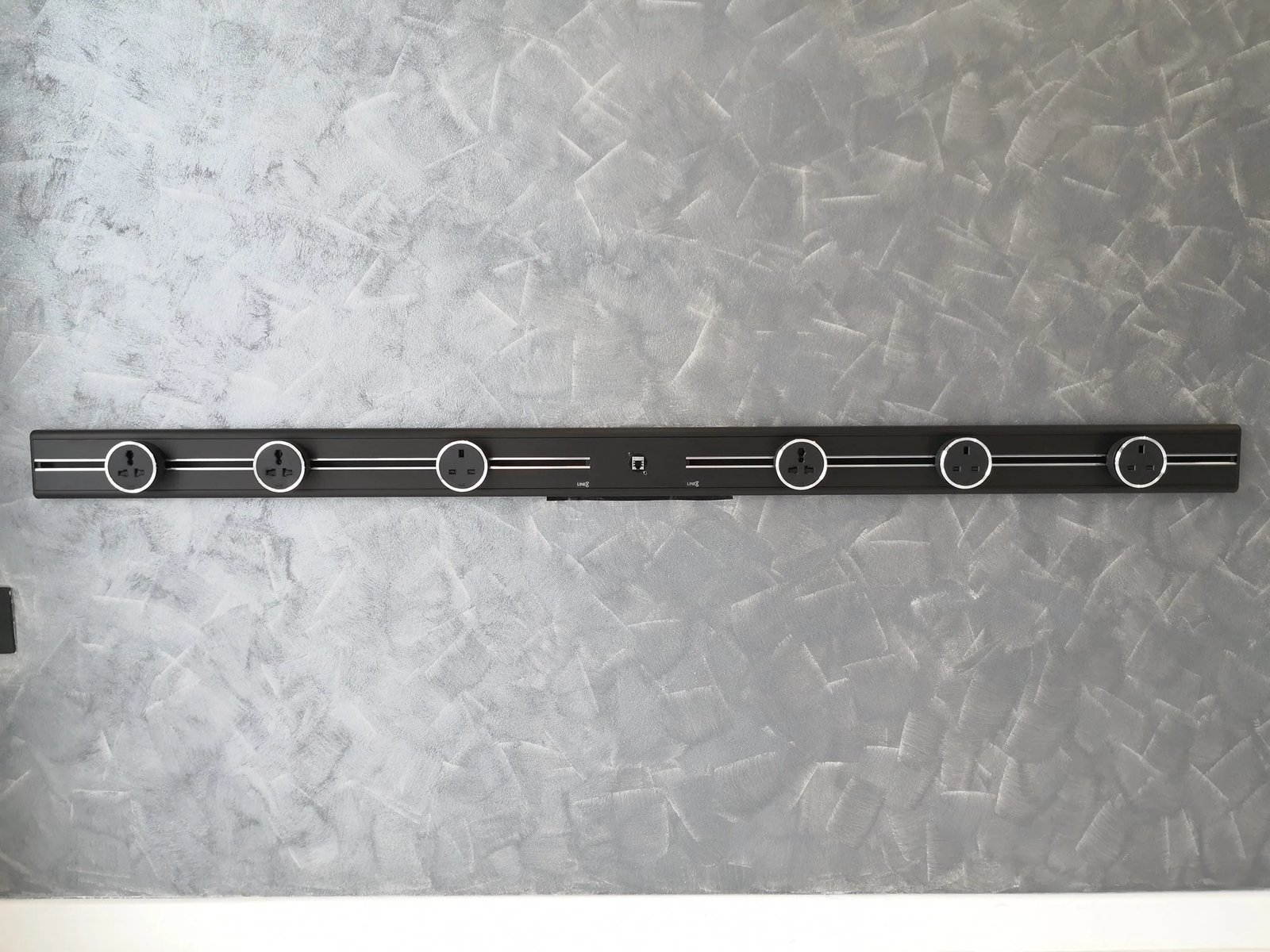 Line8 Model SL track in Black Hairline mounted on a textured wall