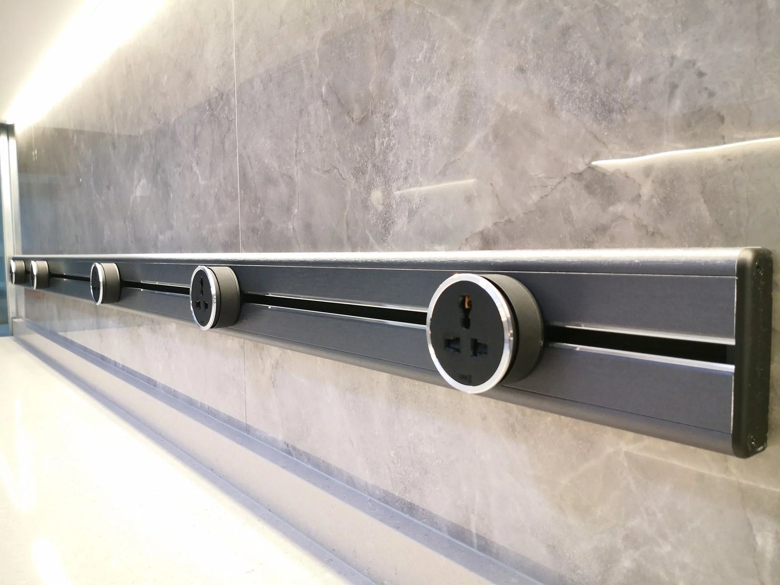Line8 Model SL track in Silver Hairline mounted on a wall, powering devices in a living area