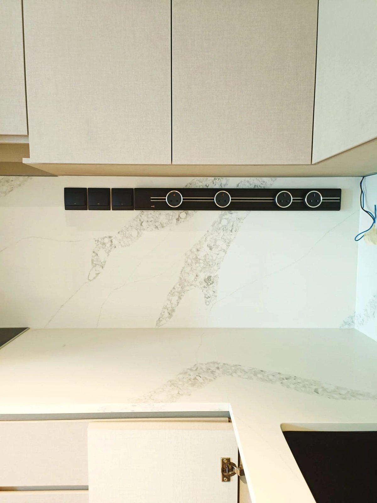 Line8 Model SL track in Black Hairline above a kitchen countertop with power adaptors