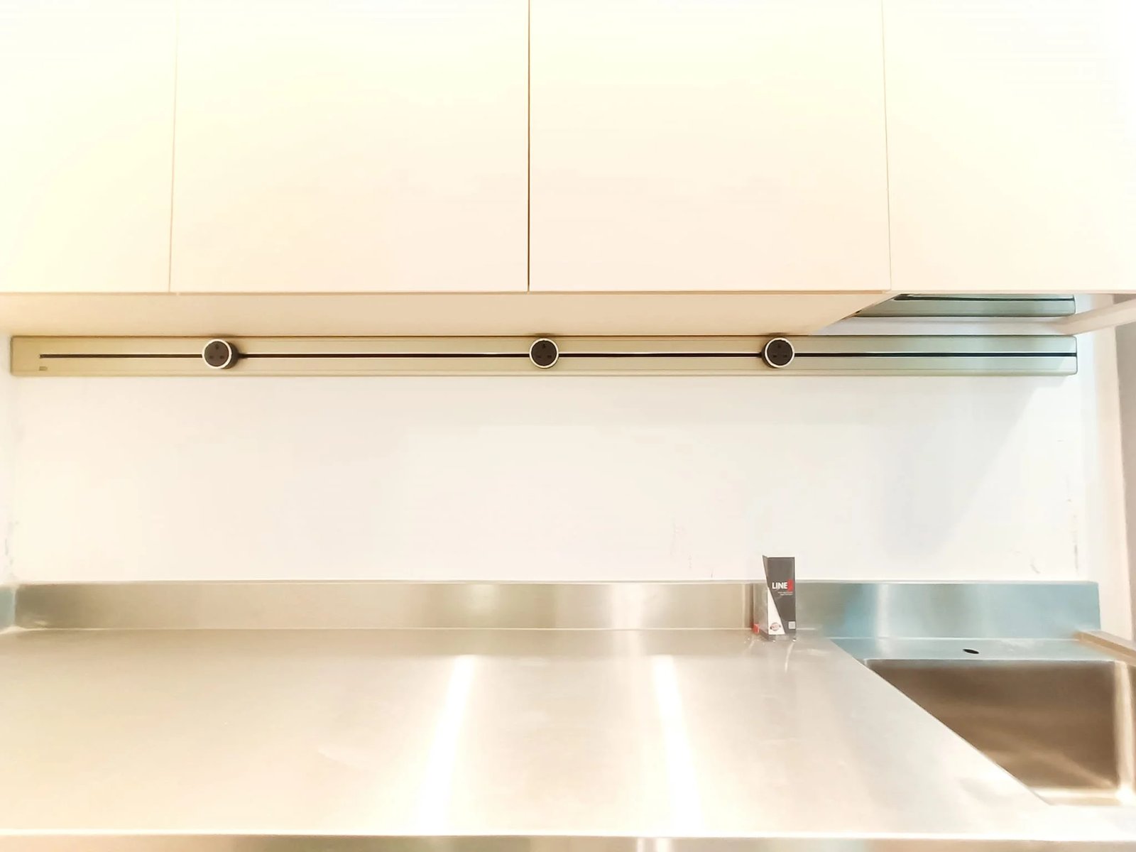 Line8 Model SL track in Champagne Gold above a stainless steel countertop