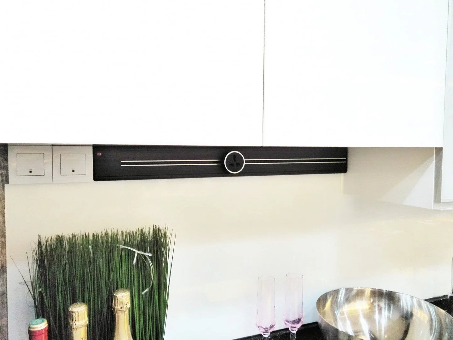 Line8 Model SL track in Black Hairline above a kitchen countertop powering outlets and lighting