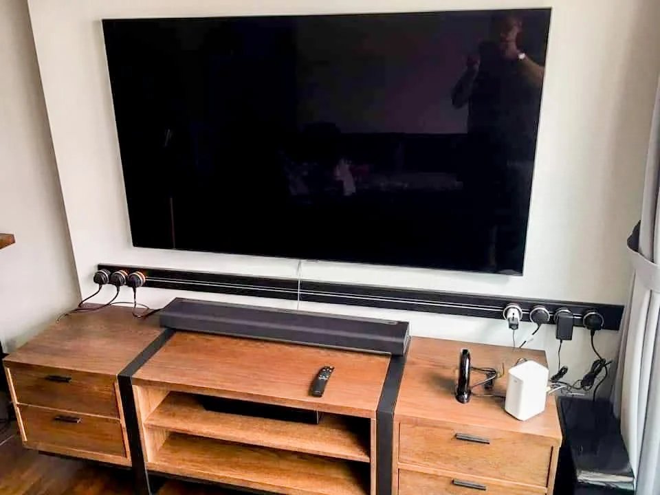 Line8 Model SL track in Black Hairline below a wall-mounted TV in the living room