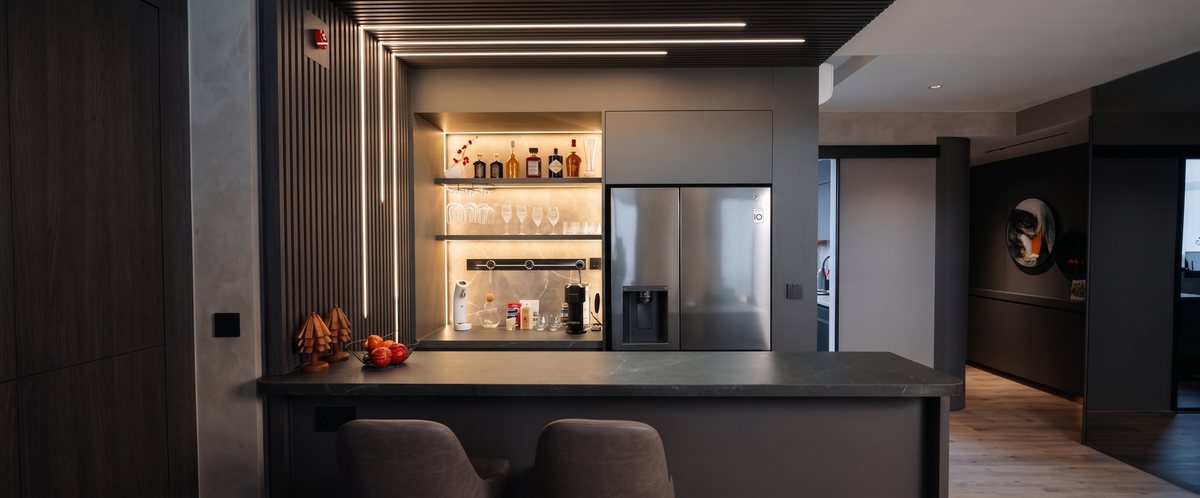 A moody wet bar and pantry with a Line8 adaptor track visible above the counter