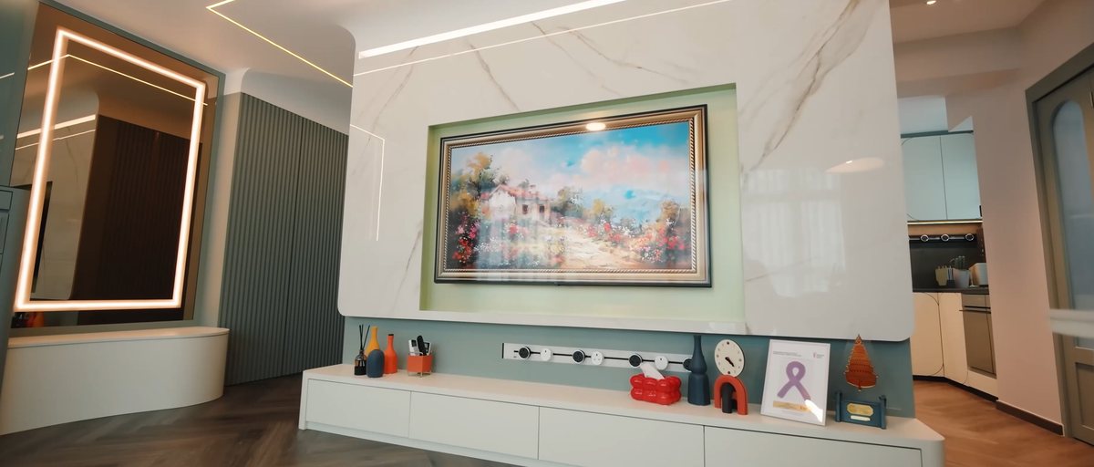 A colourful showroom wall with six mixed black and white Line8 adaptors on a track beneath a TV console