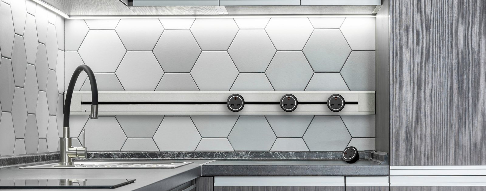 Zen Series adaptors on a Line8 Zen Track above a kitchen countertop with hexagon tile backsplash