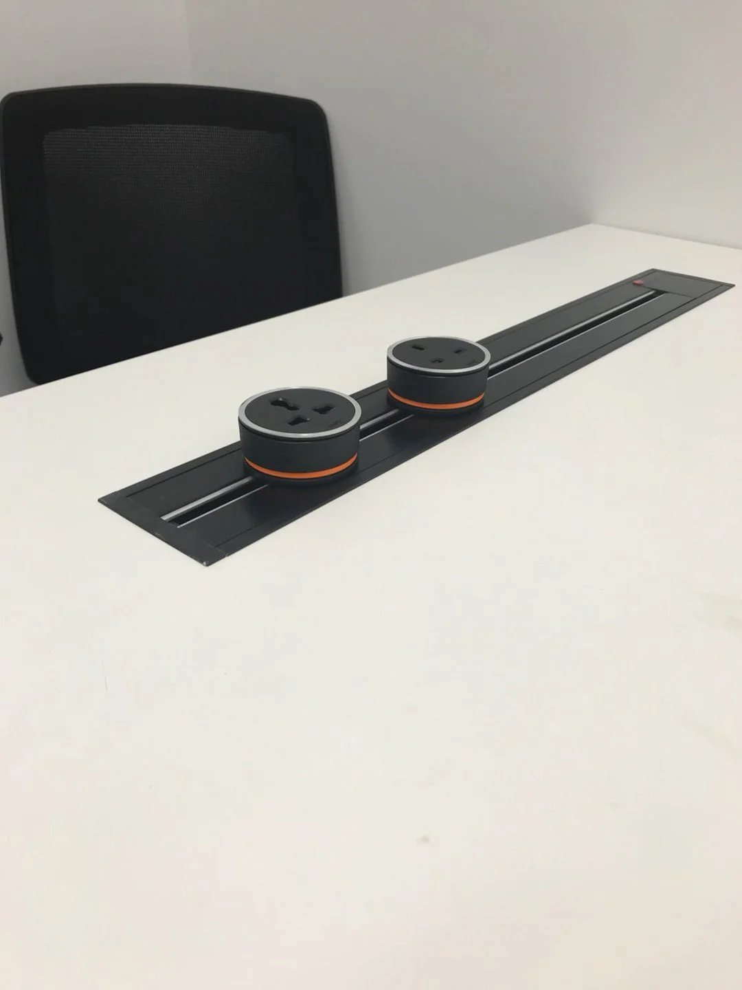 Line8 Model SL track in Black Hairline on a conference table powering two adaptors