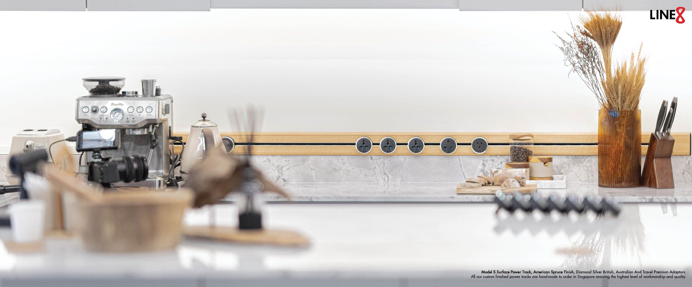 Line8 power track, American Spruce finish, integrated into a marble kitchen countertop