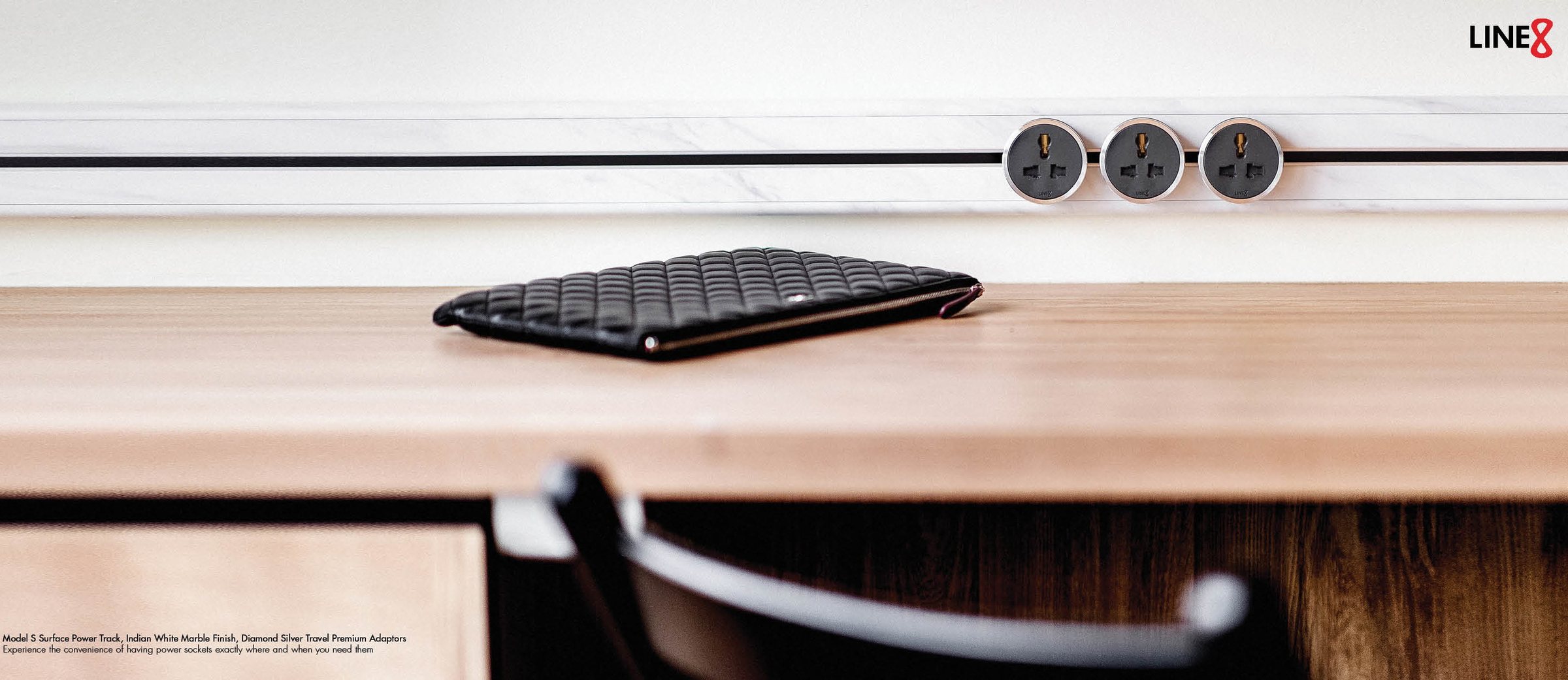 Line8 power track, Indian White Marble finish, on a desk with premium adaptors