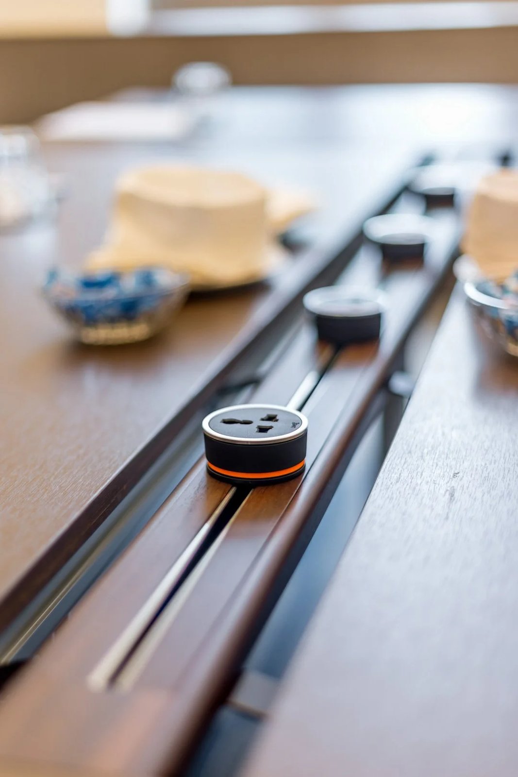 Line8 Model SL track in Burmese Teak within a conference room powering devices on the table