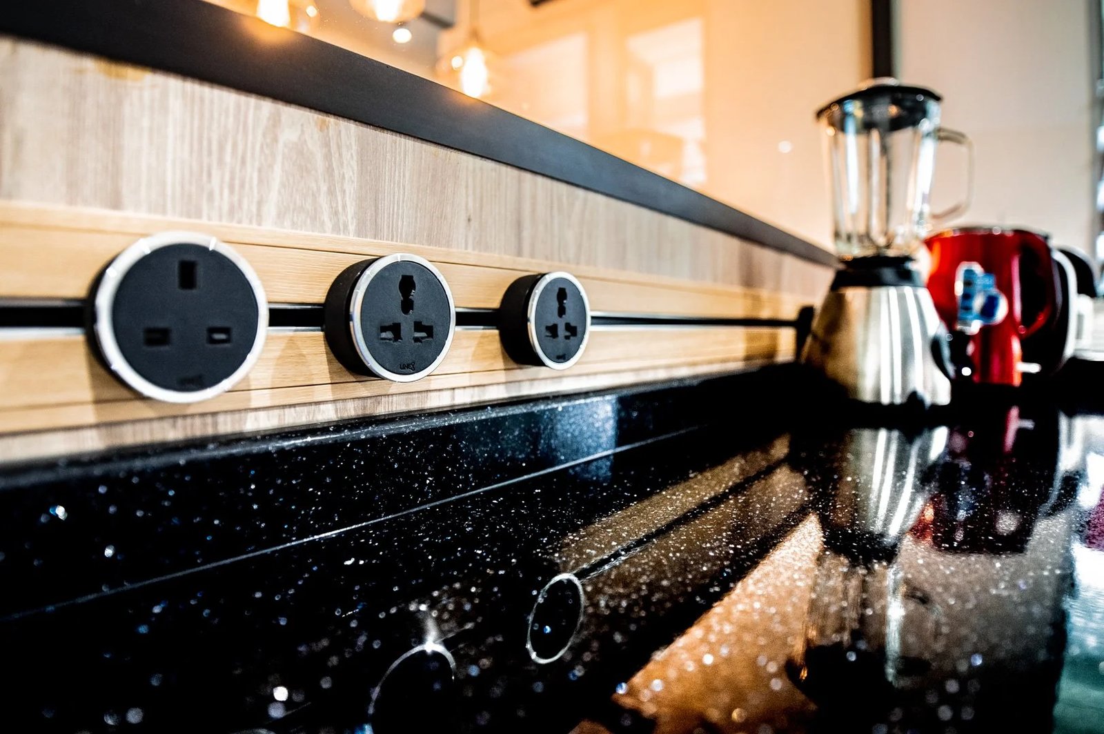 Line8 Model SL track in Black Hairline along a kitchen countertop with power outlets