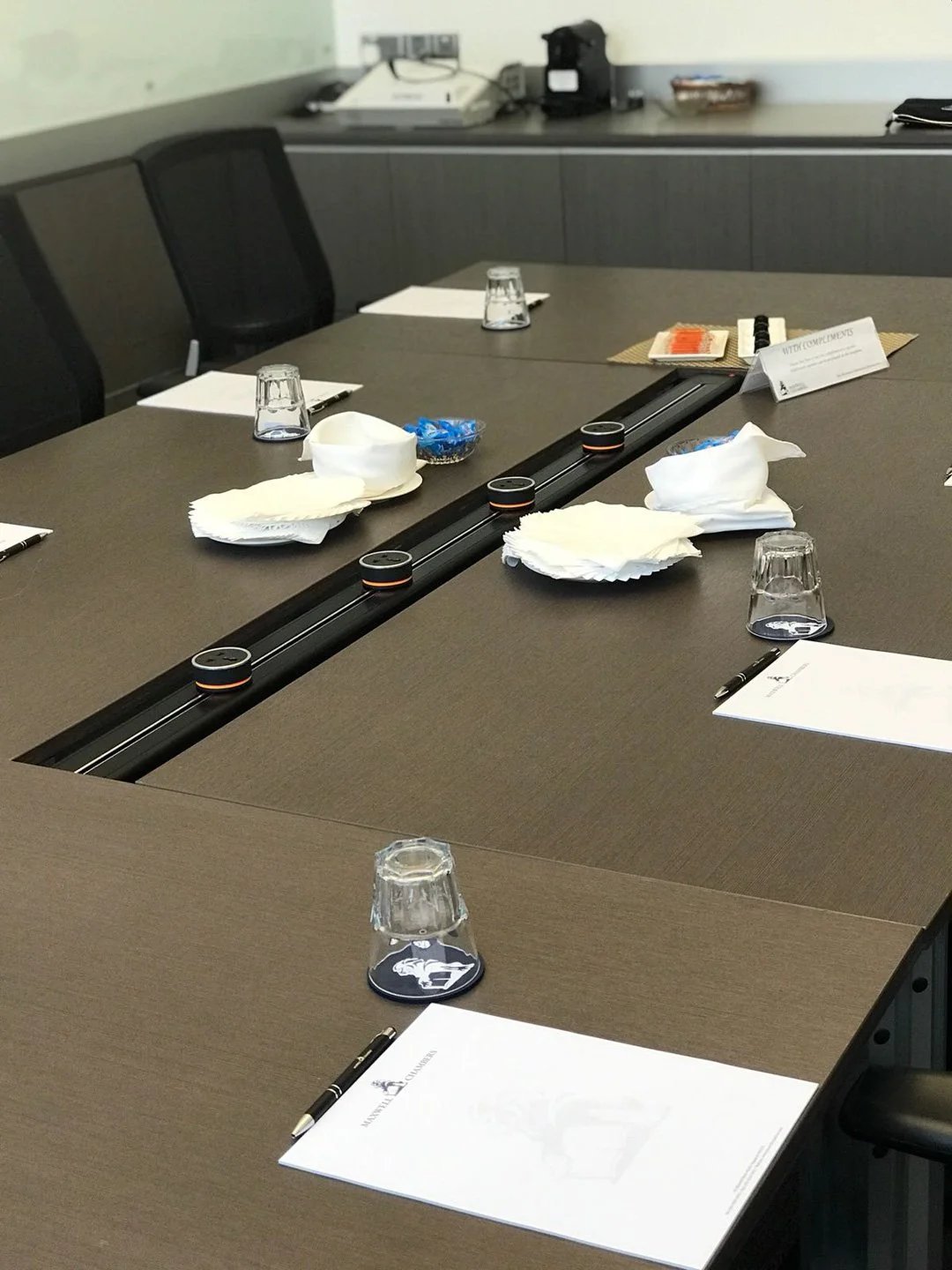 Line8 Model SL track in Black Hairline on a conference table powering devices during a meeting
