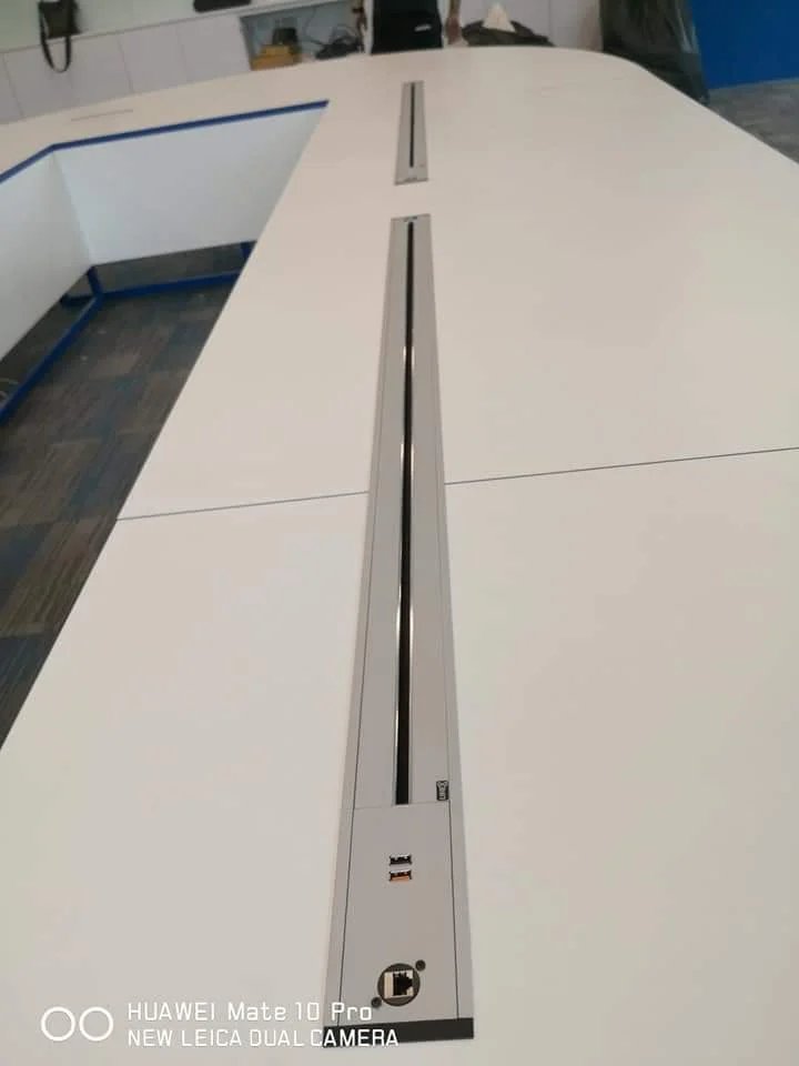 Line8 Model SL track in Silver Hairline on a conference table powering devices