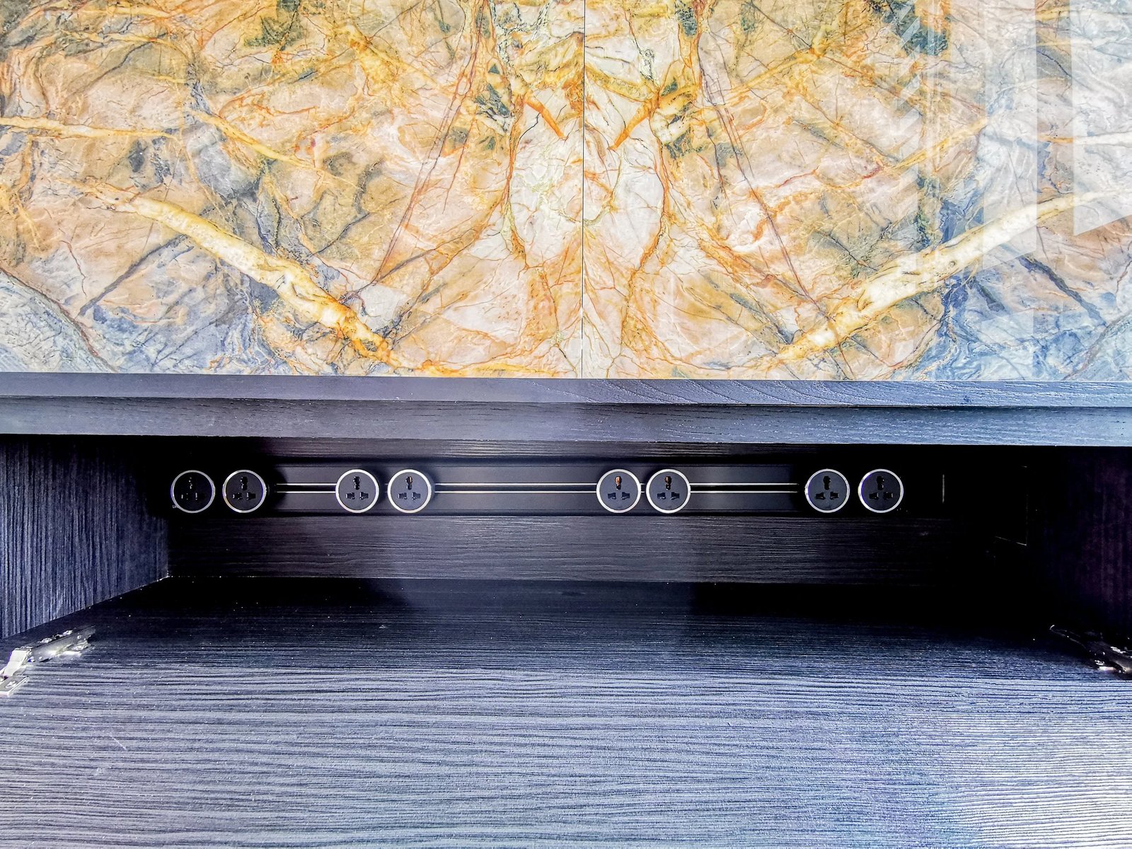 Line8 Model SL track in Black Hairline below a decorative wall panel in a living area