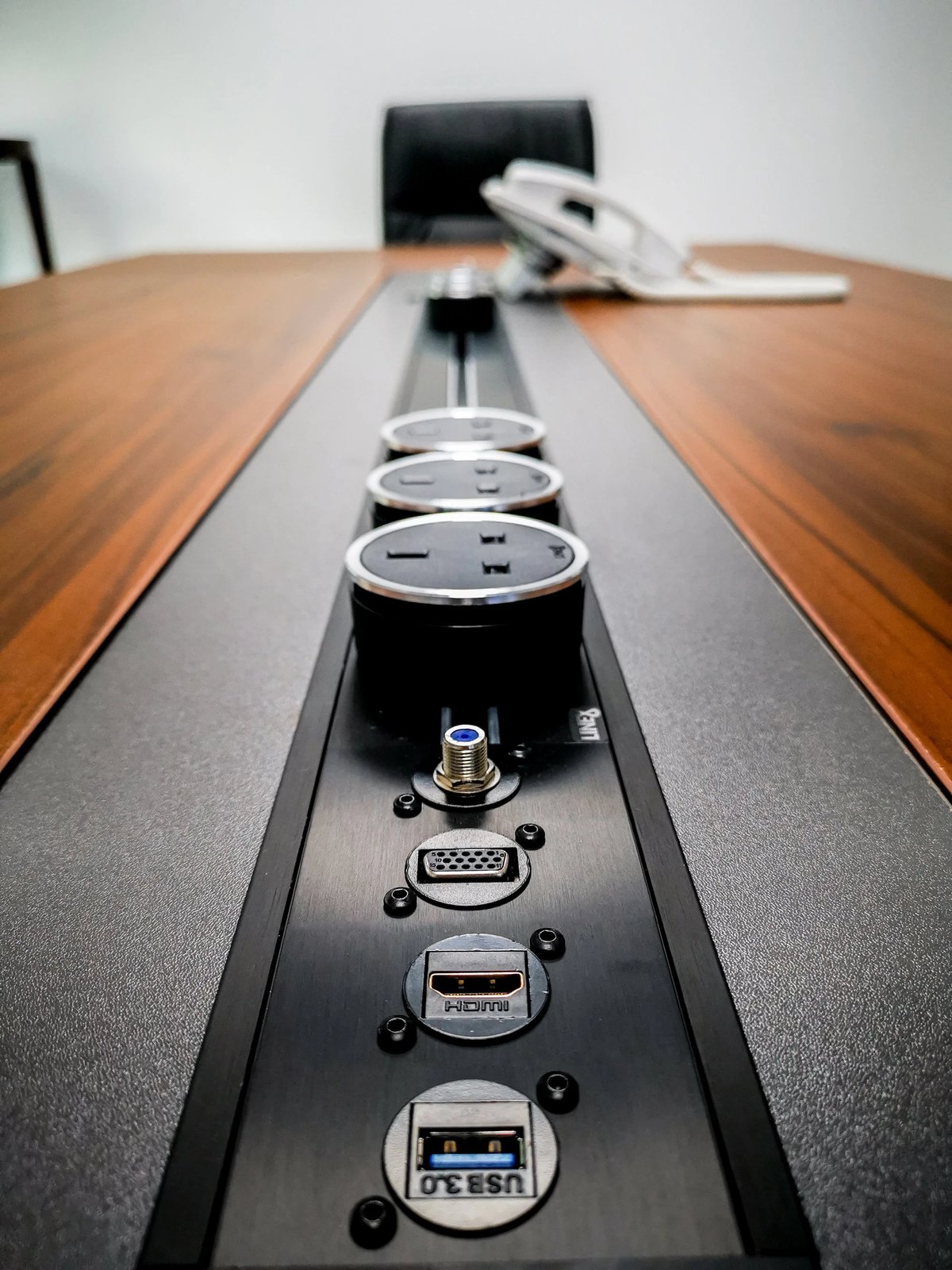 Line8 Model SL track in Black Hairline along a conference table powering USB and HDMI ports
