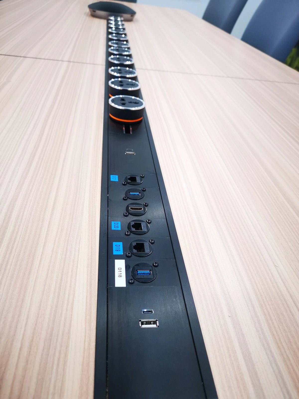Line8 Model SL track in Black Hairline along a conference table powering devices