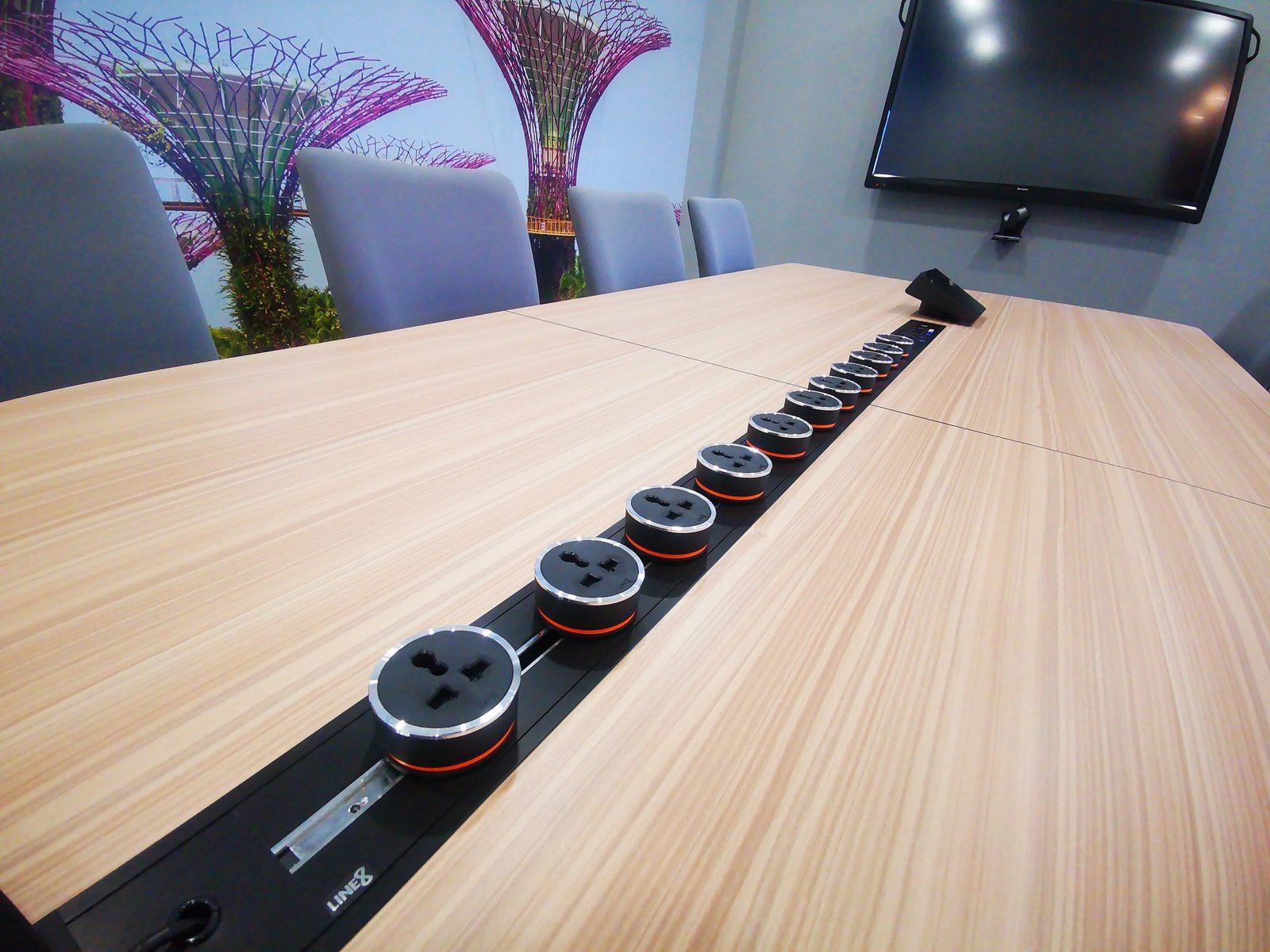 Line8 Model SL track in Black Hairline along a conference table powering devices