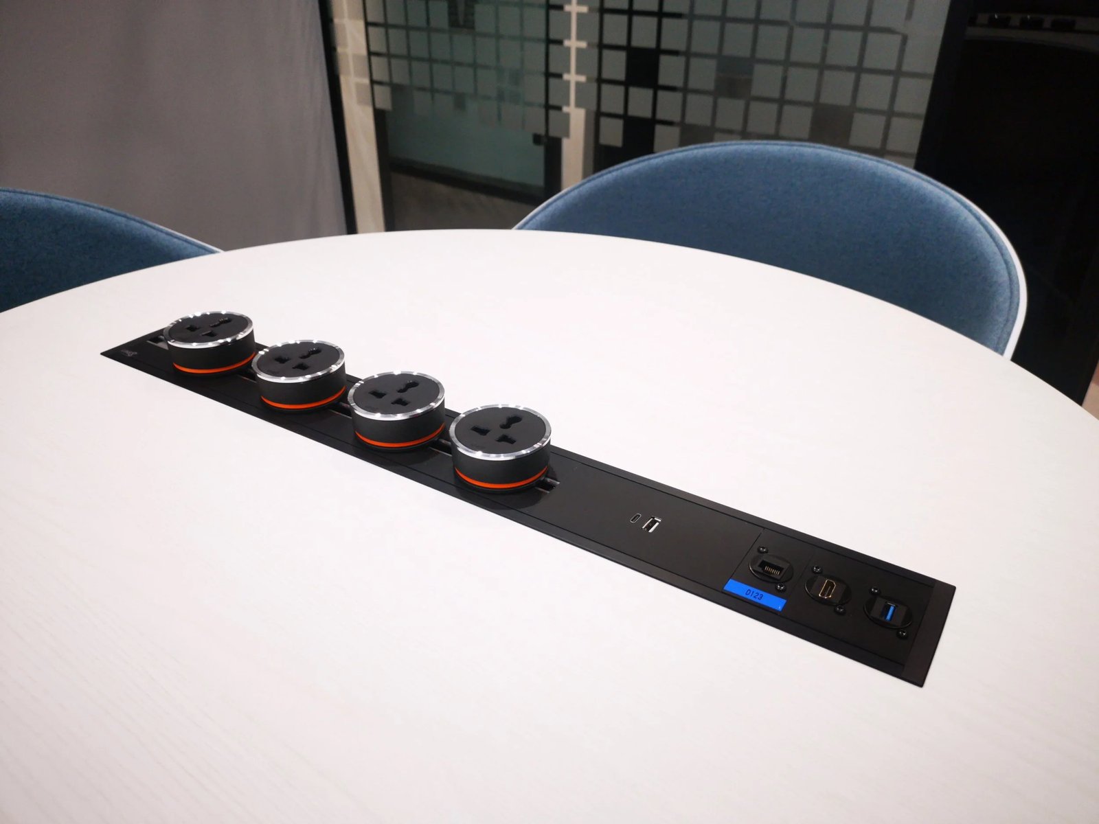 Line8 Model SL track in Black Hairline on a conference table powering multiple devices