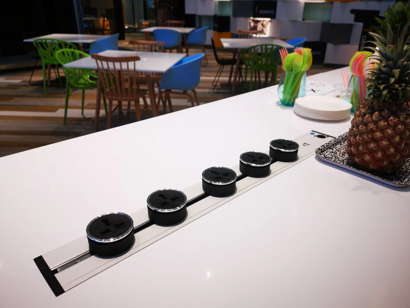 Line8 Model SL track in Black Hairline on a conference room table powering devices