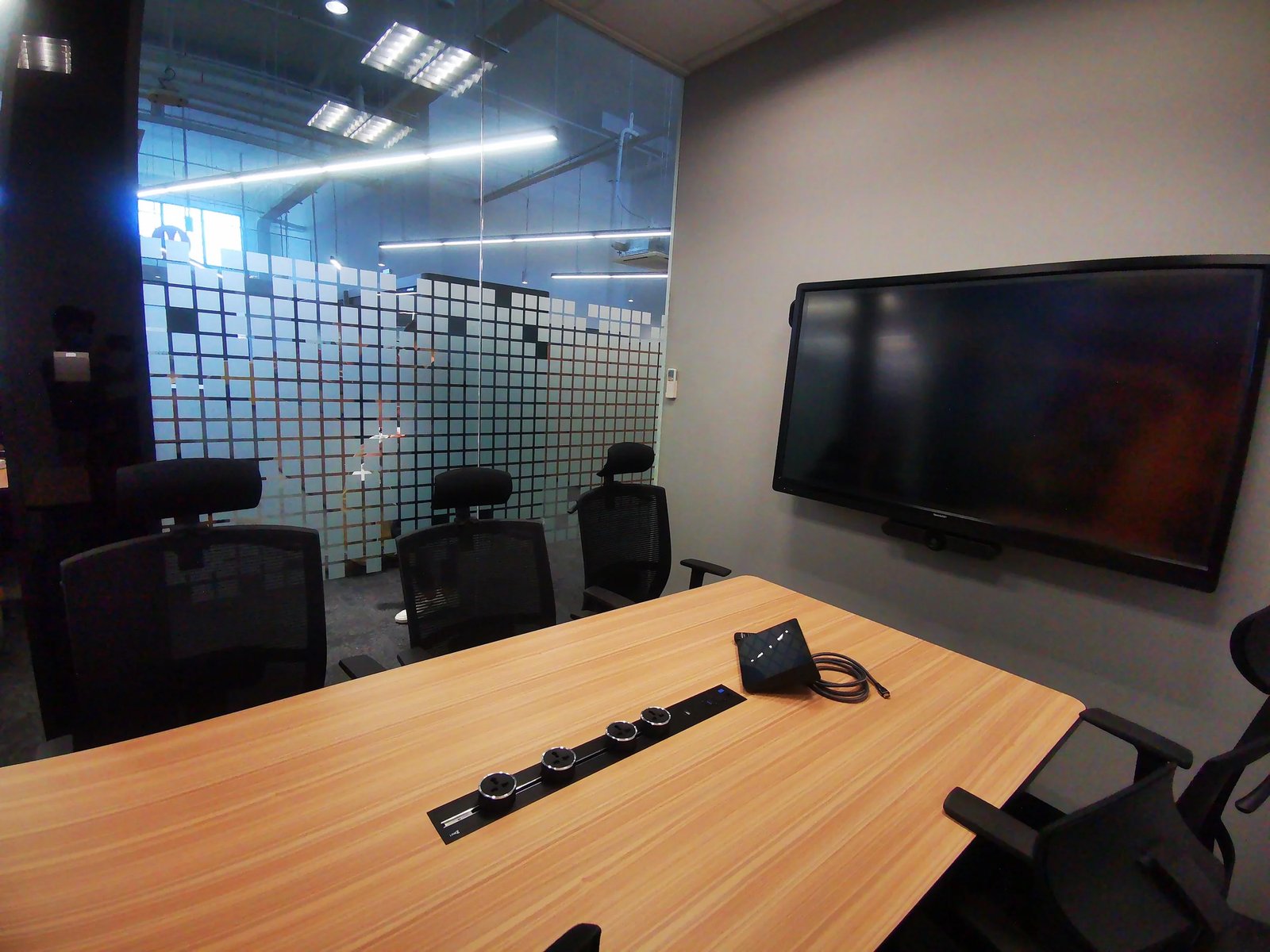 Line8 Model SL track in Black Hairline above a conference table powering devices