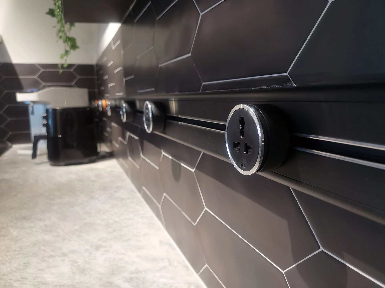 Line8 Model SL track in Black Hairline along a kitchen wall powering outlets