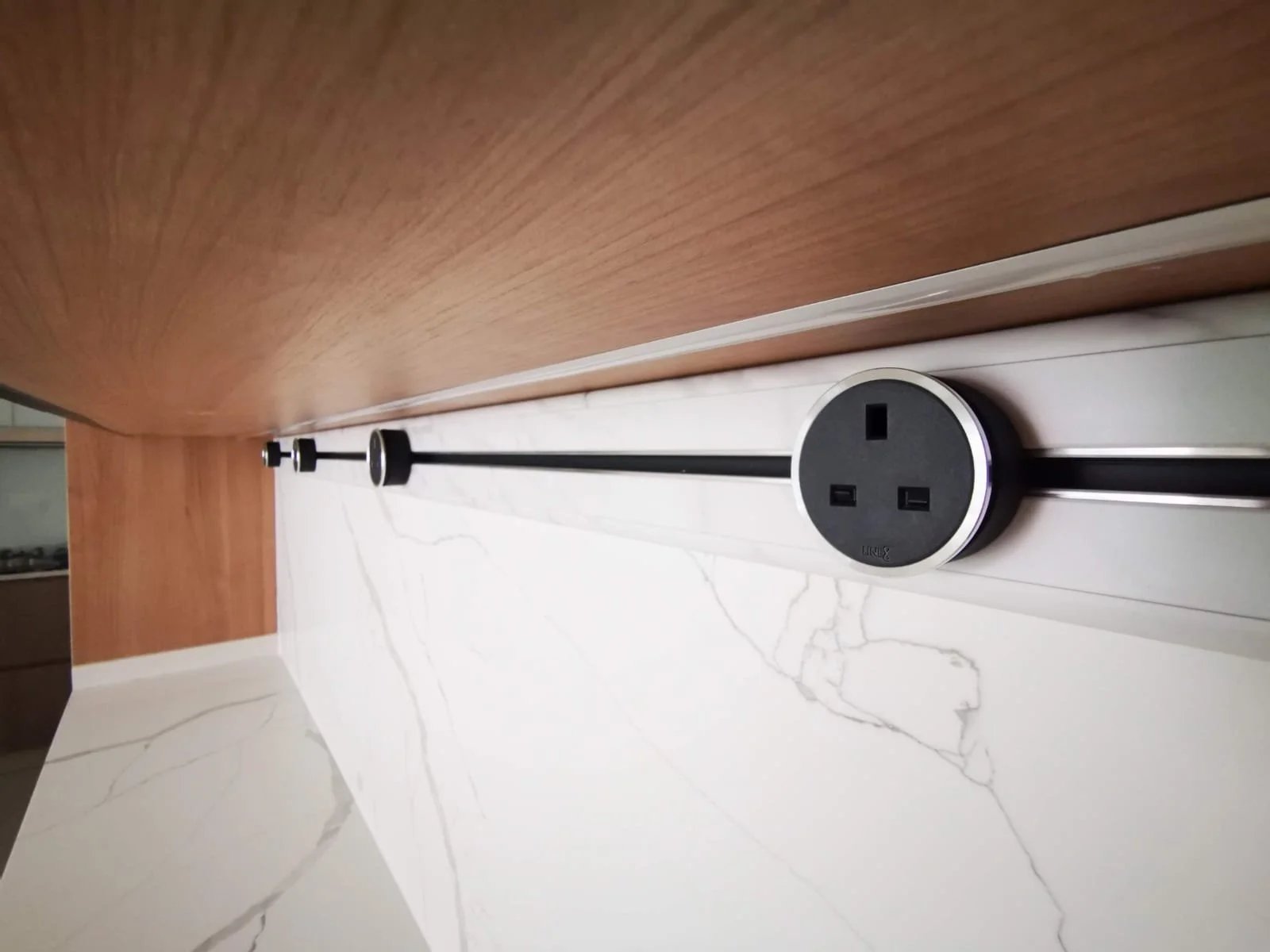 Line8 Model SL track in Black Hairline above a kitchen splashback with power outlets