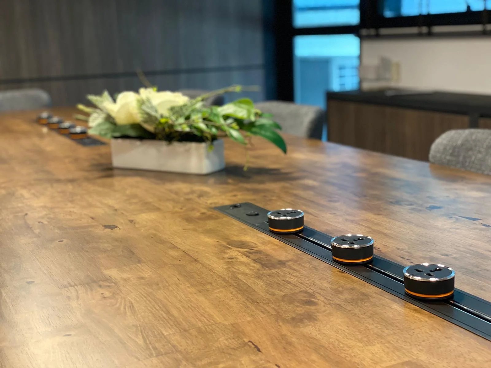 Line8 Model SL track in Black Hairline along a conference room table with adaptors