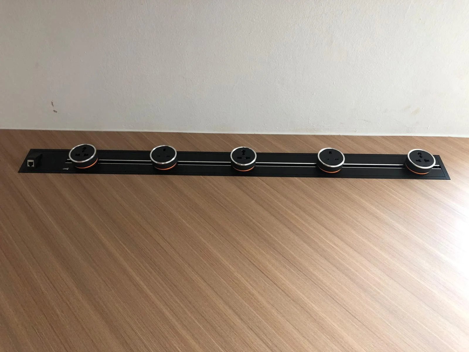 Line8 Model SL track in Black Hairline on a wooden surface with multiple adaptors