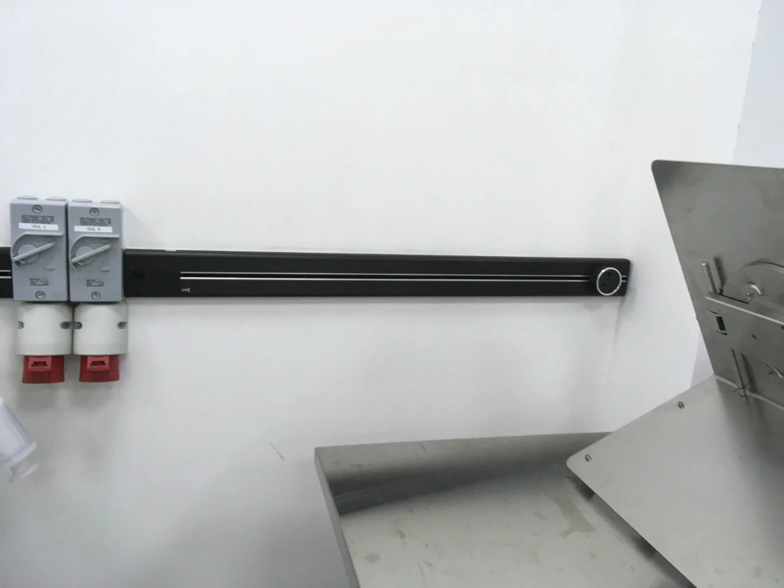Line8 Model SL track in Black Hairline above a laboratory workbench powering equipment