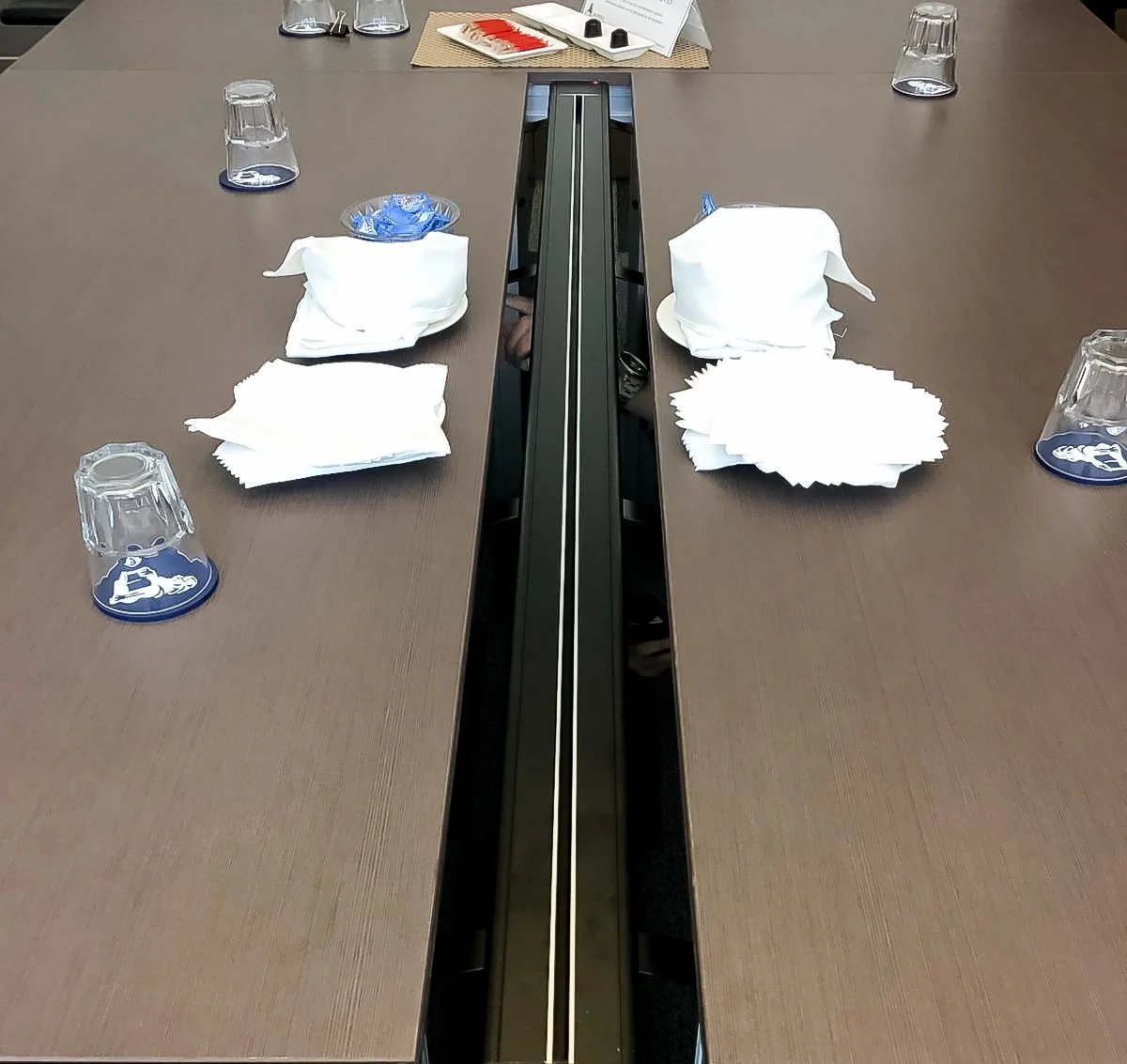 Line8 Model SL track in Silver Hairline on a conference table powering devices