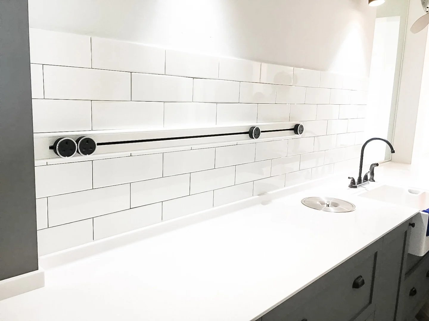 Line8 Model SL track in Black Hairline above a kitchen sink with power adaptors