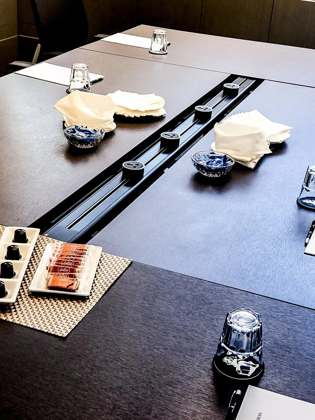 Line8 Model SL track in Black Hairline on a conference table powering devices