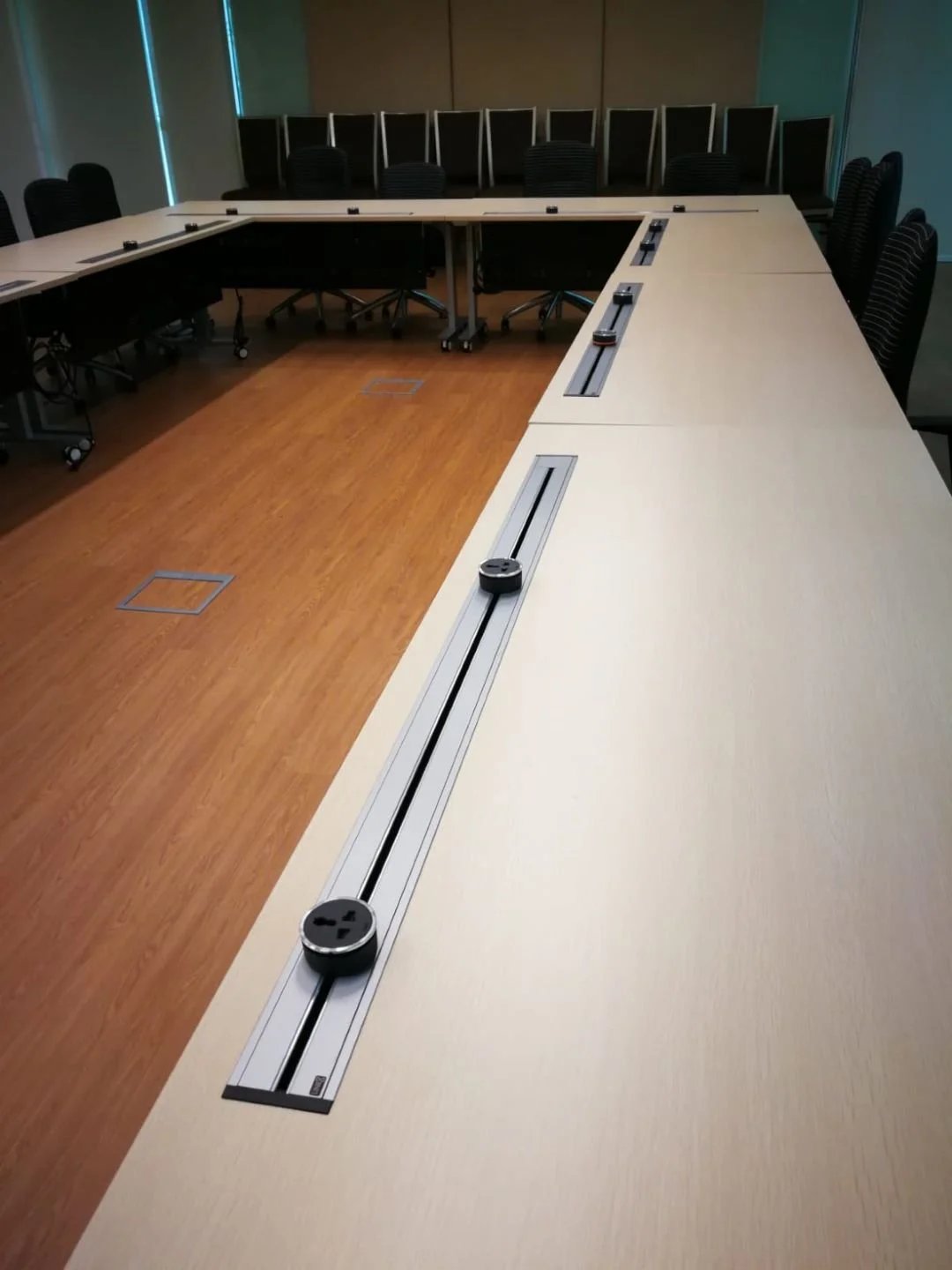 Line8 Model SL track in Silver Hairline along a conference table powering devices